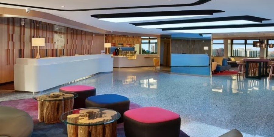 A contemporary hotel lobby with an assortment of bright, colorful furniture designed for relaxation and socializing.